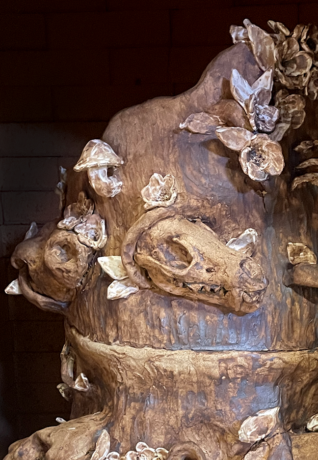 Close up of ceramic artwork featureing an animal skull and plants