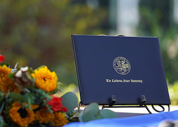 Fresno State Degree folio in with flowers.