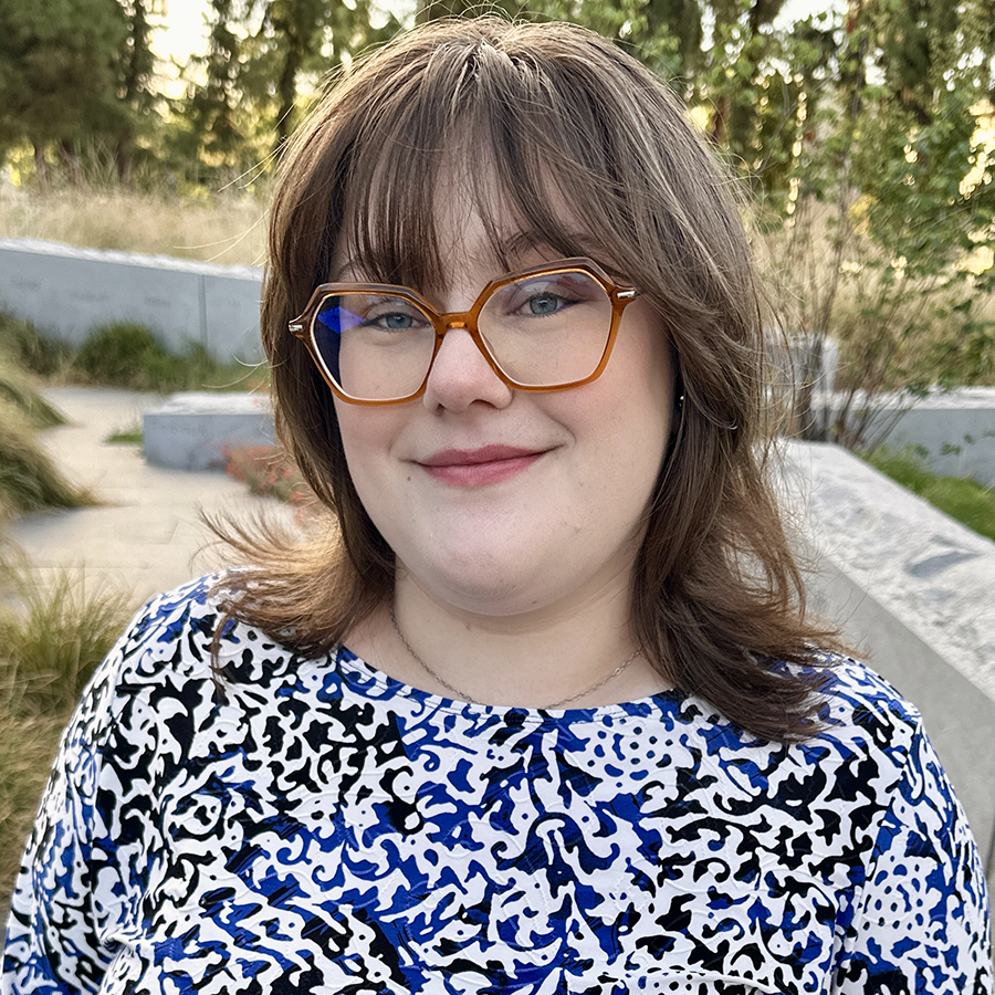 Headshot photo of Stephanie with greenery in background.