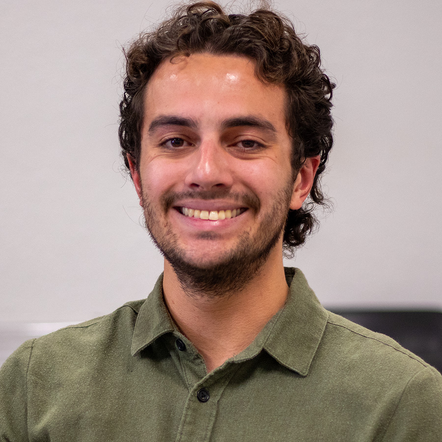 Headshot of Seth with classroom desks in background.