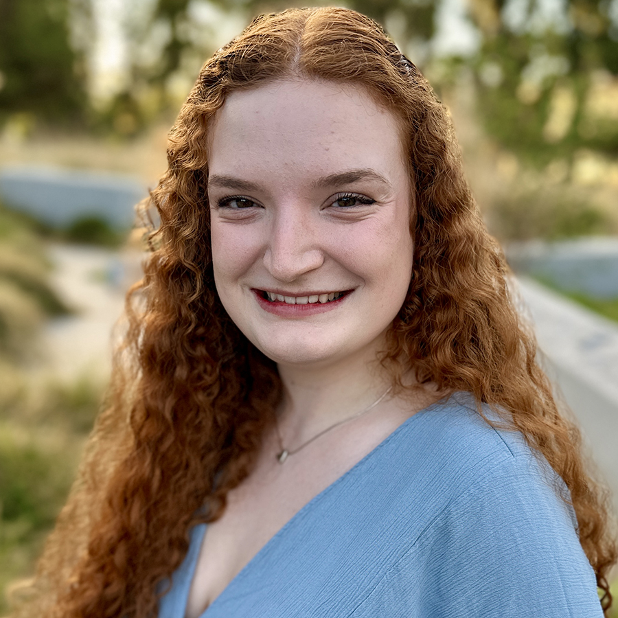Headshot of Mariah with greenery in background.