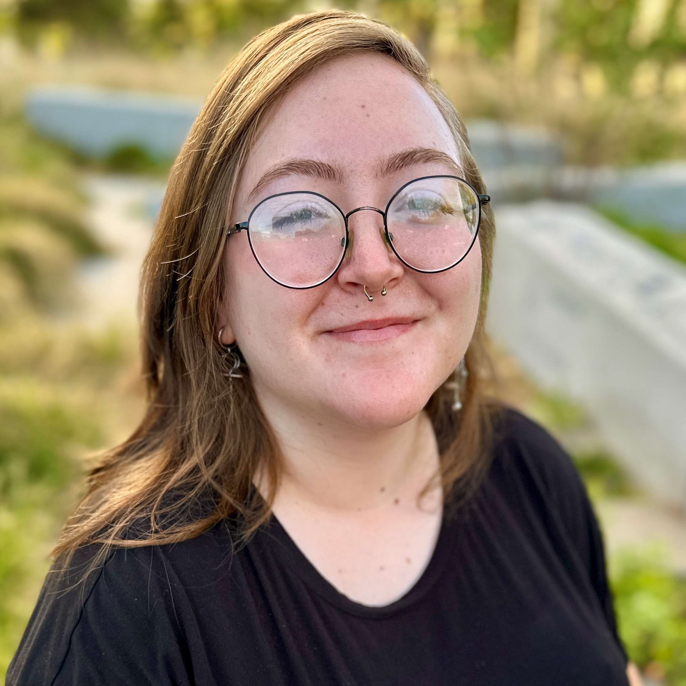 Headshot of Jessika with greenery in background.