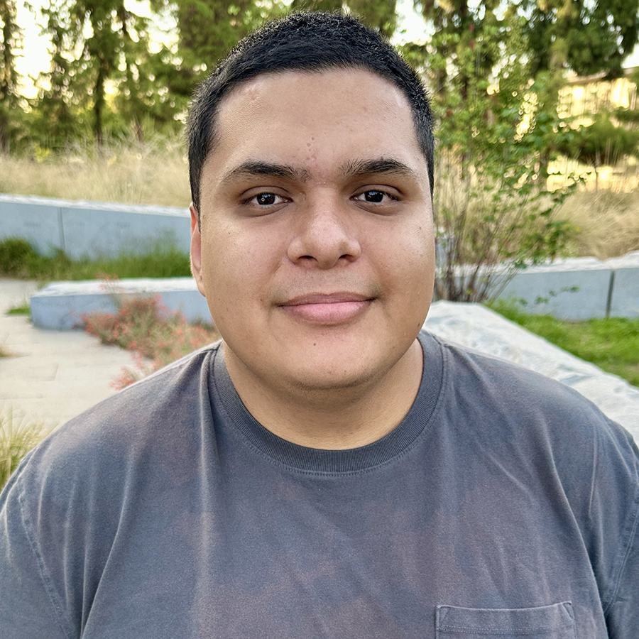 Headshot of Anthony with greenery in background
