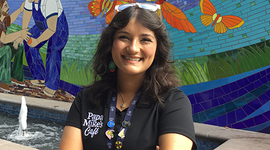 Headshot of Mary Sosa with a colorful mural in the background.