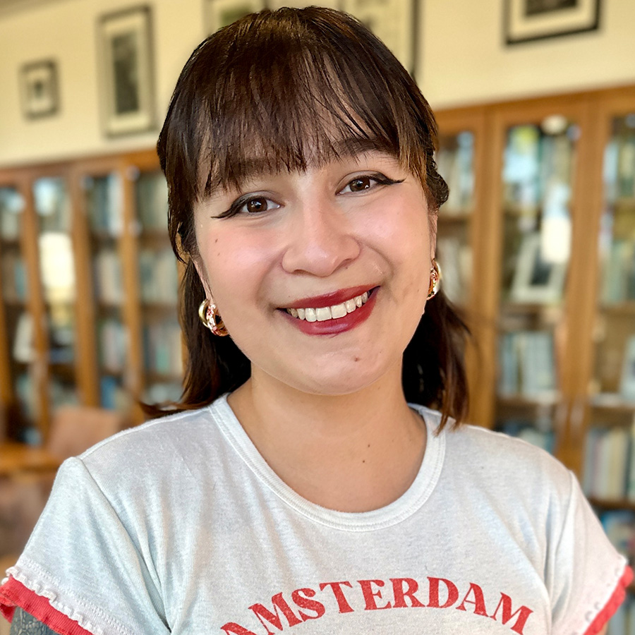 Headshot of Antonia with bookshelves in background.