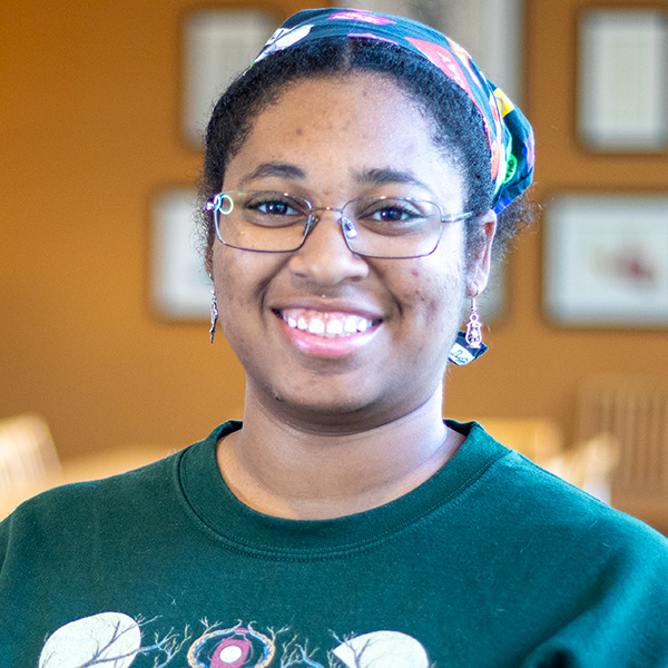 Headshot photo of Kaylynn inside the library.