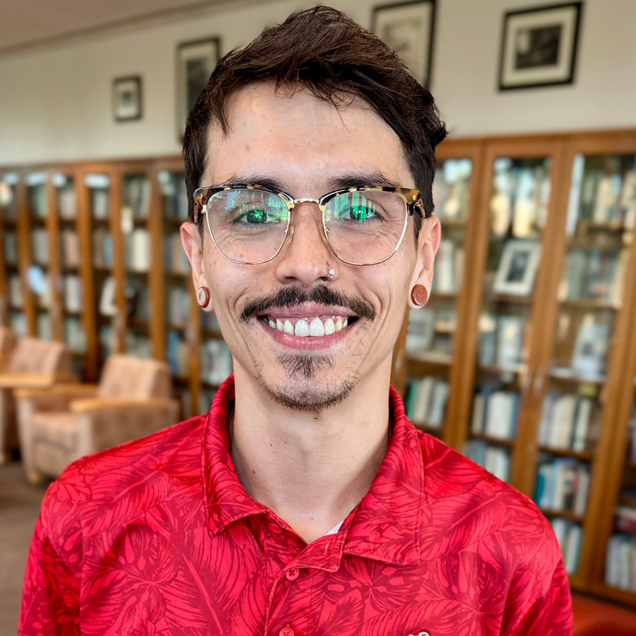 Headshot of Steven with books on bookshelves in background.