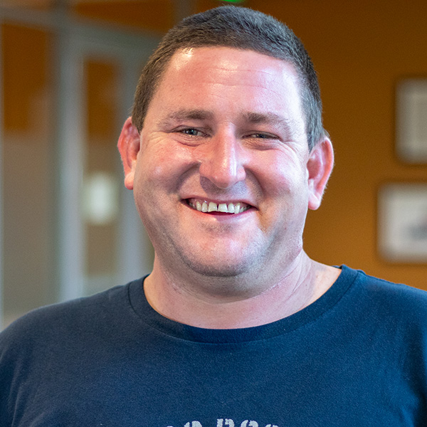 Headshot photo of Jacob inside the library.