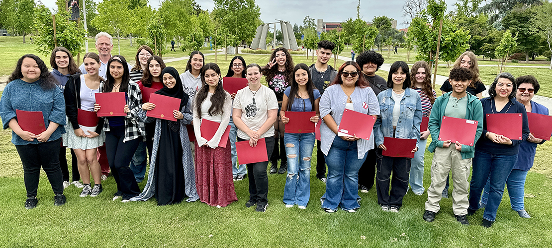 2024 award winners gather on campus with their awards certificates