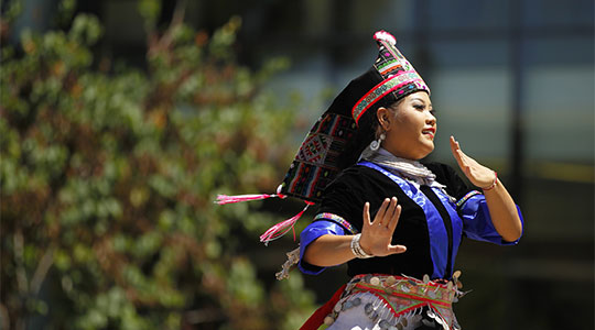 Hmong dancer in front of Henry Madden Library