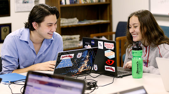 Two Communication Students on their computers