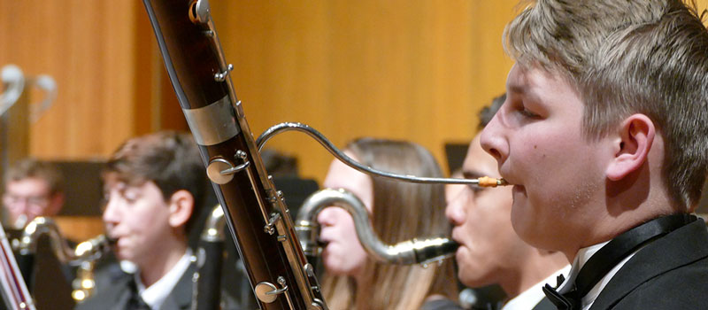 Student plays an oboe during a music performance