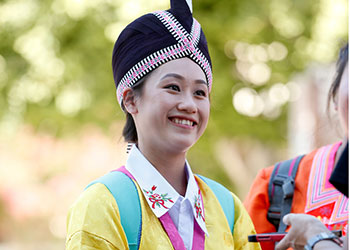 Hmong student dressed in traditional brightly colored clothes.