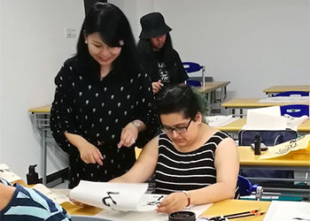 Professor looks over a student's work in the classroom.