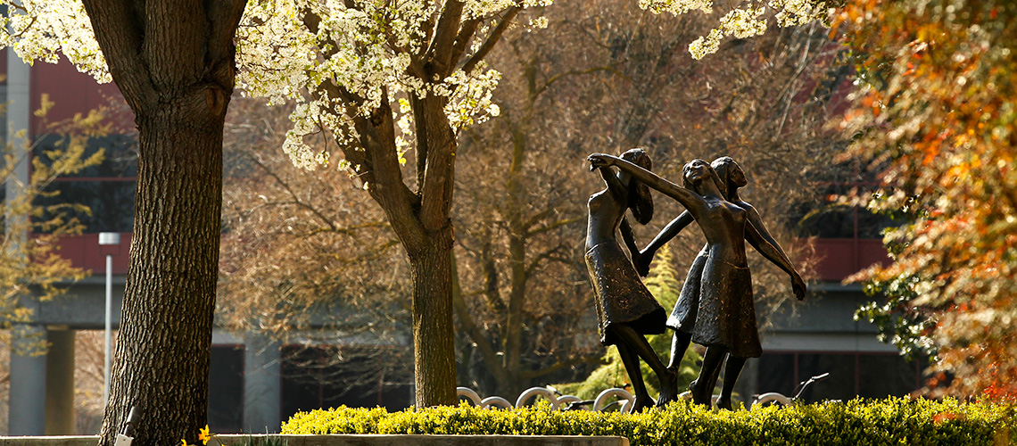 Entrance to the Music Building - Three Graces sculpure surrounded by fall colors