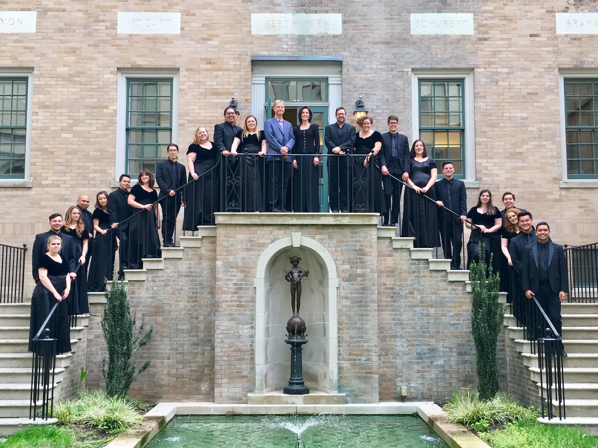 Fresno State Chamber Singers posing for a picture on a set of stairs at the Library of Congress. Everyone is smiling while looking at the camera.