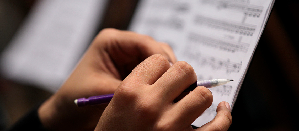 Student makes notes on sheet music.