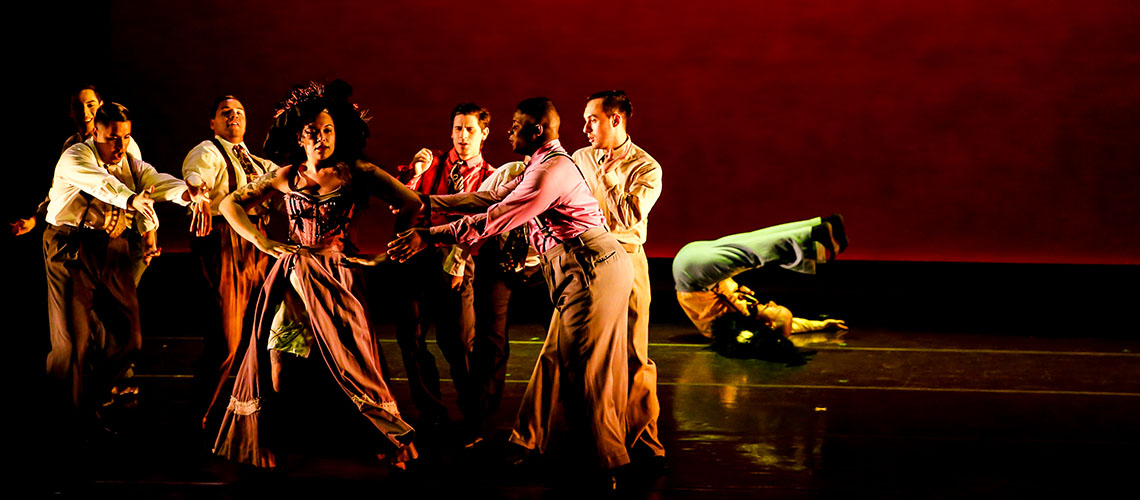 Image of dancers in dramatic pose on empty stage