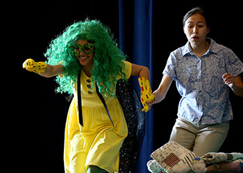 Alexis Elisa Macedo in a super-hero pose as she leads another woman to safety during the play "The Super Cilantro Girl" adapted from a book of the same name by Juan Felipe Herrera. 